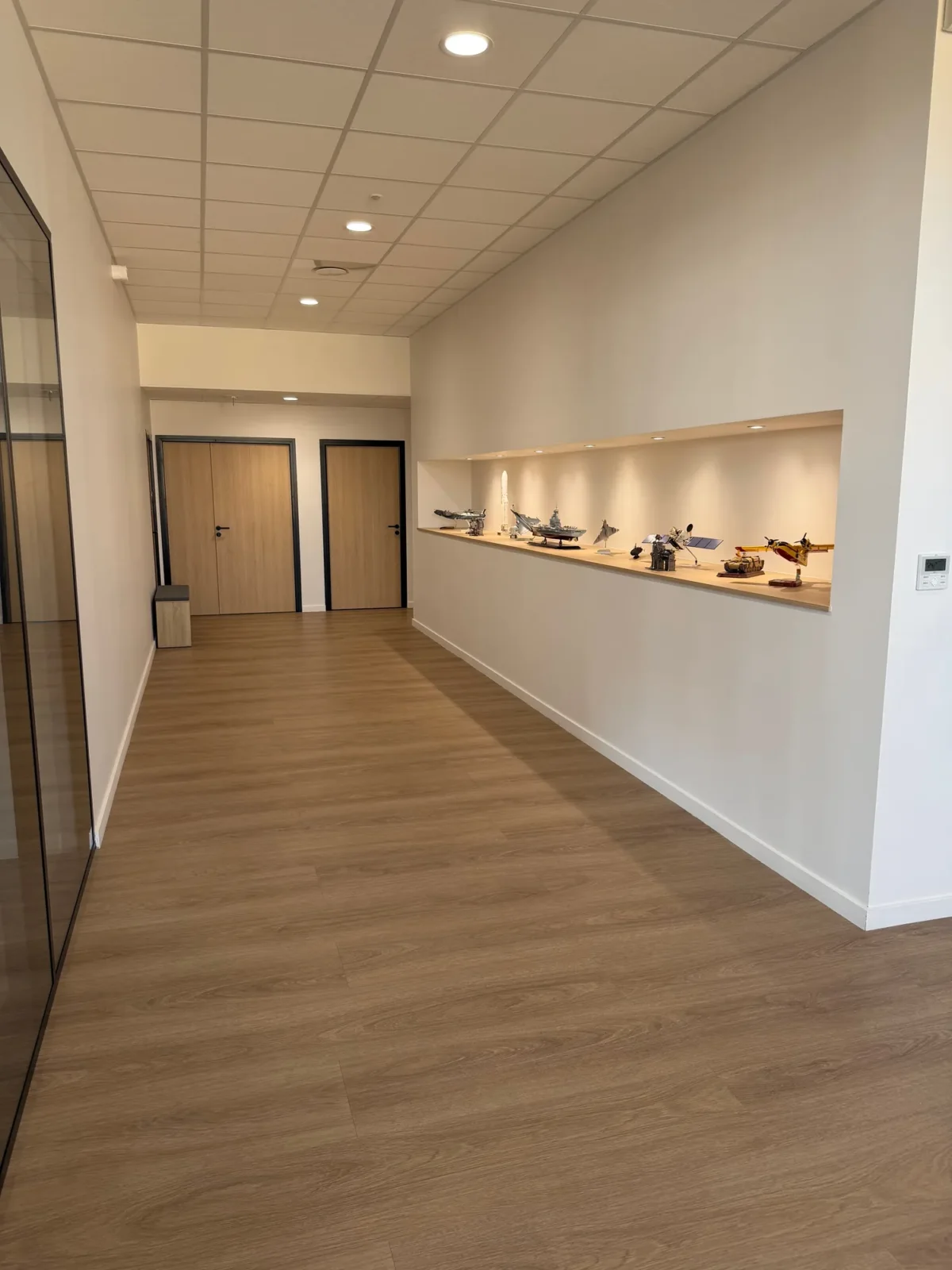 Couloir de bureaux avec éclairage encastré dans le plafond à Rillieux-la-Pape, chantier ECP illustrant la pose de faux plafonds