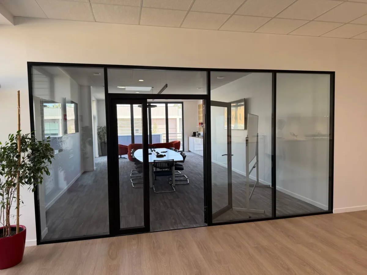 Cloison vitrée de type atelier fermant une salle de réunion à Rillieux-la-Pape, chantier ECP illustrant la pose de cloisons amovibles et sèches